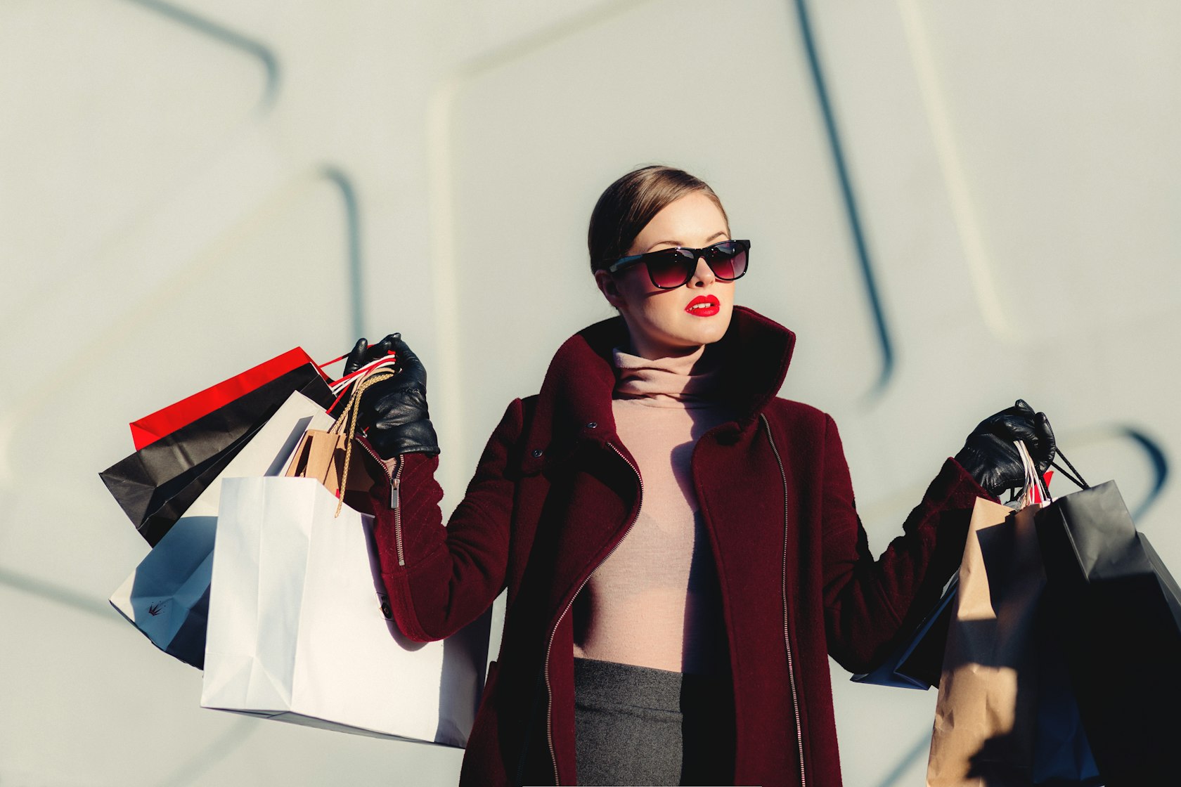 A woman in a deep burgundy wool coat and blush roll-neck, styled for the new season