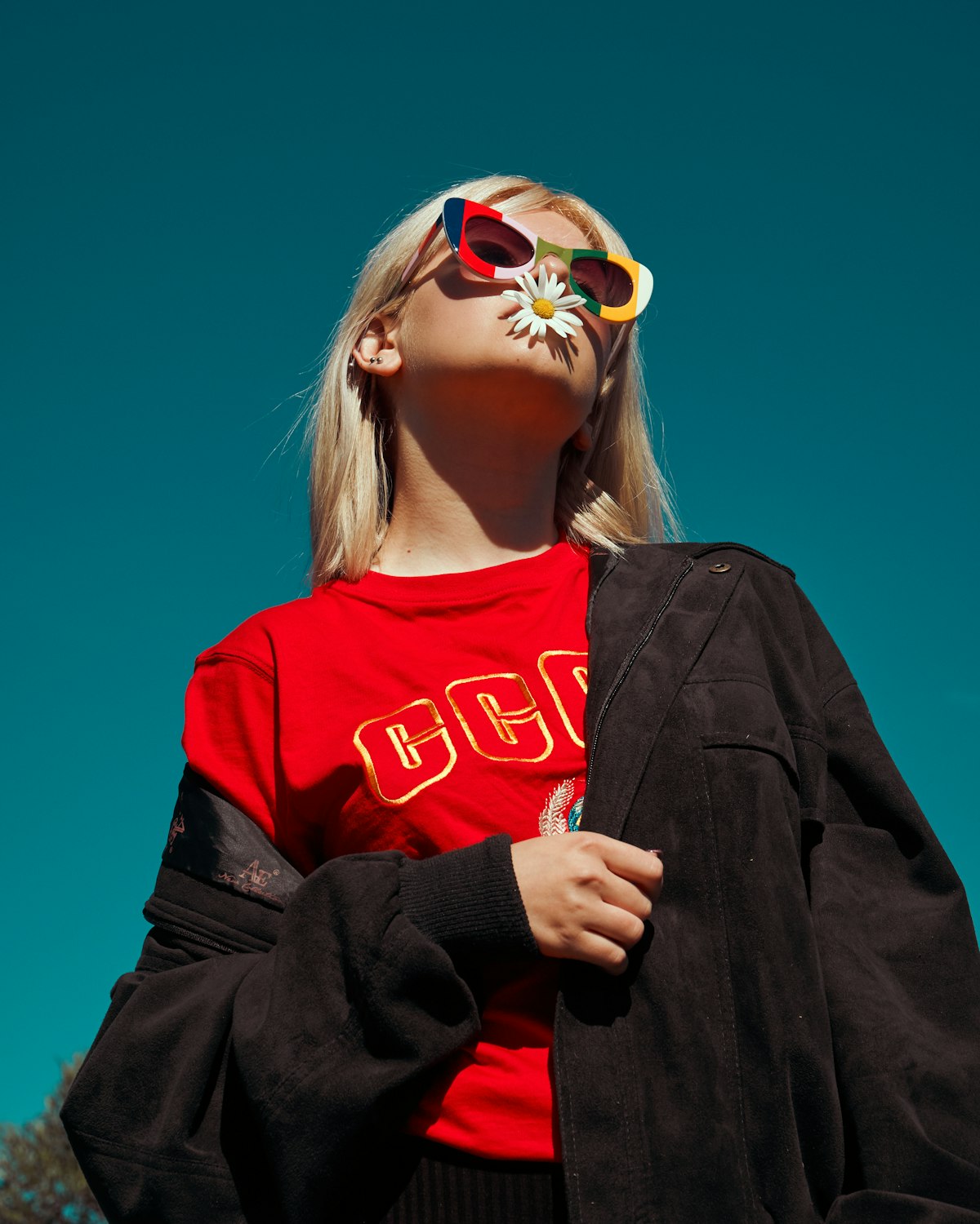 NOX Supply lookbook — model in a graphic tee and black overshirt shot under harsh flash against a deep blue sky