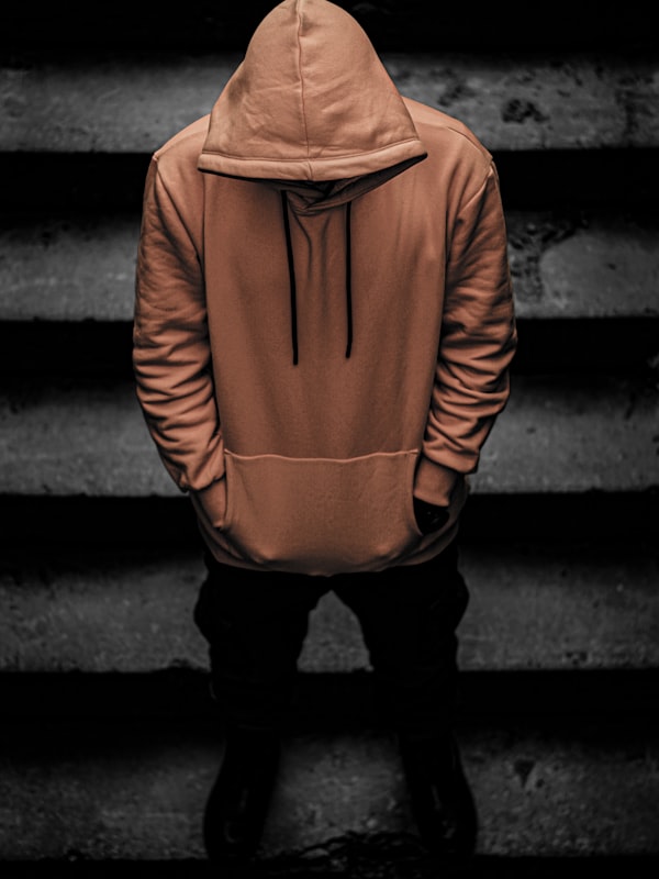 Hooded figure on dark steps wearing NOX outerwear