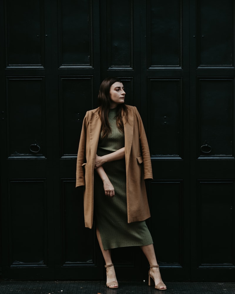 A model wrapped in a tailored wool coat in golden light