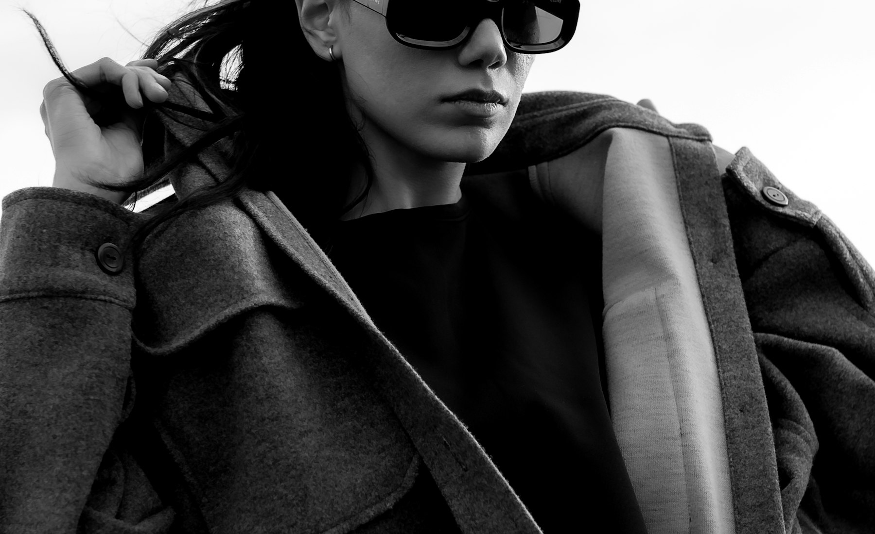 A model in a camel wool cocoon coat photographed in warm, golden autumn light