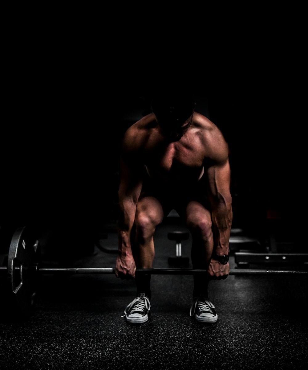 An athlete braced for a heavy lift in a dramatically lit gym
