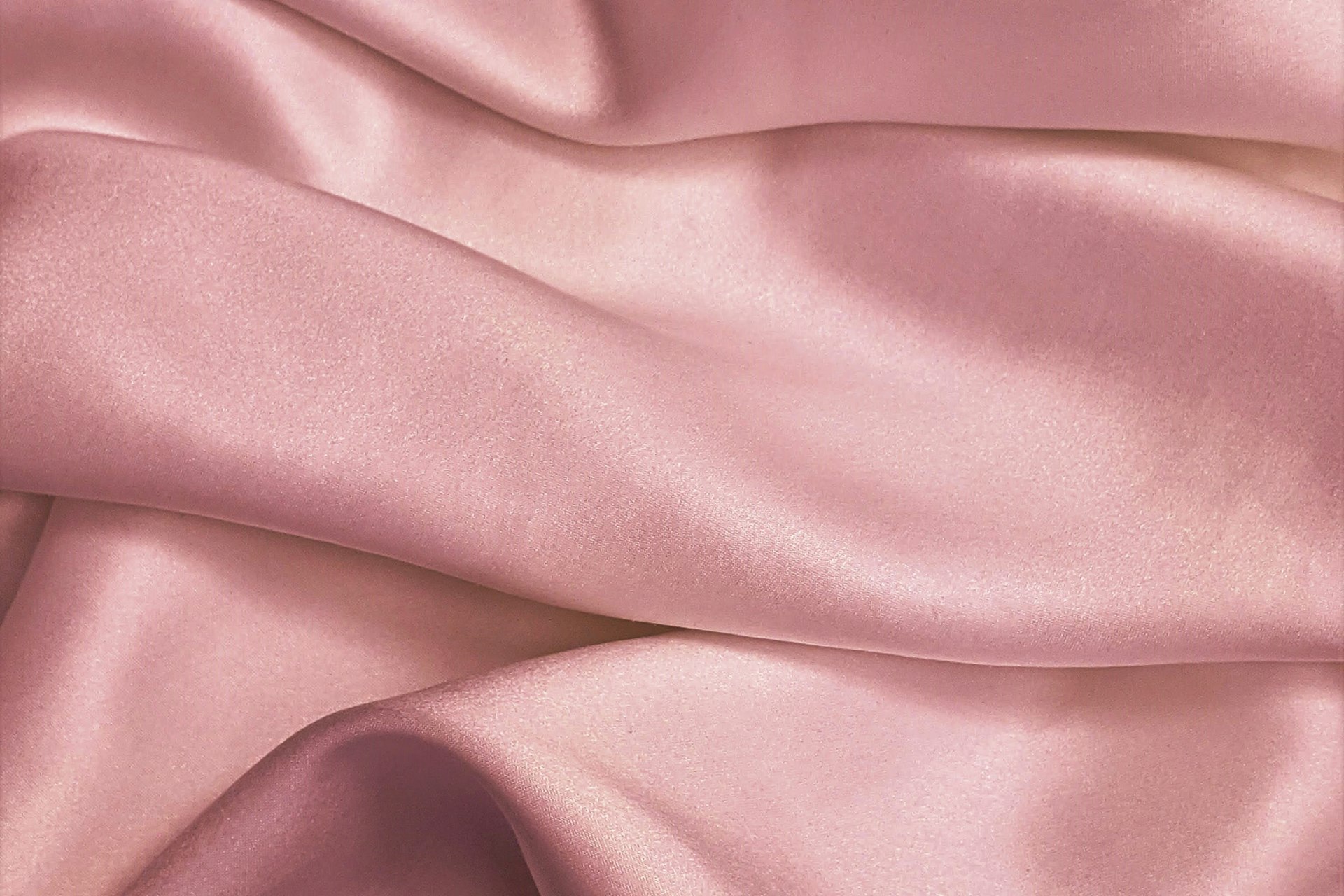 A soft fold of blush silk catching gentle light