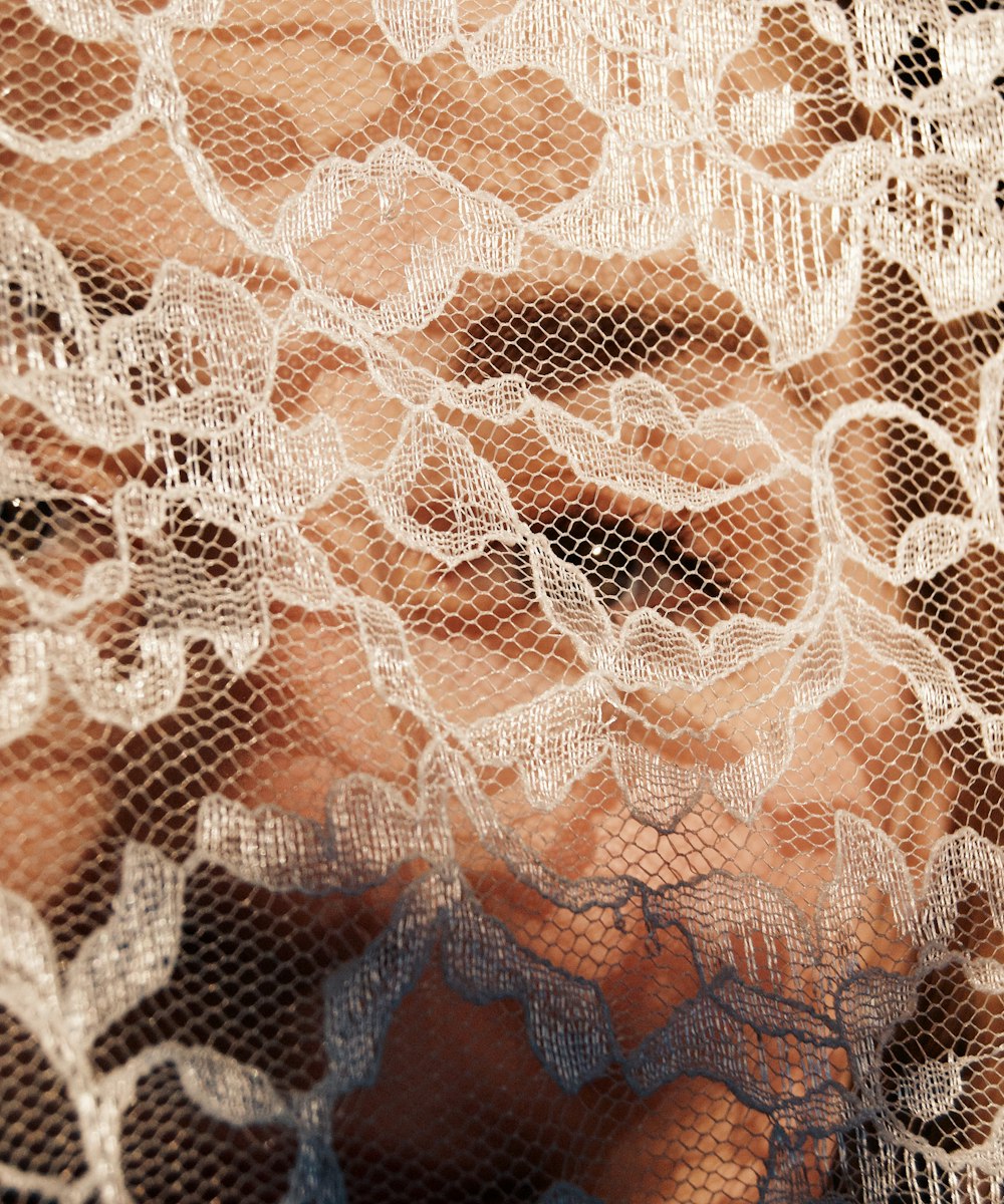 A close detail of fine blush lace catching the light