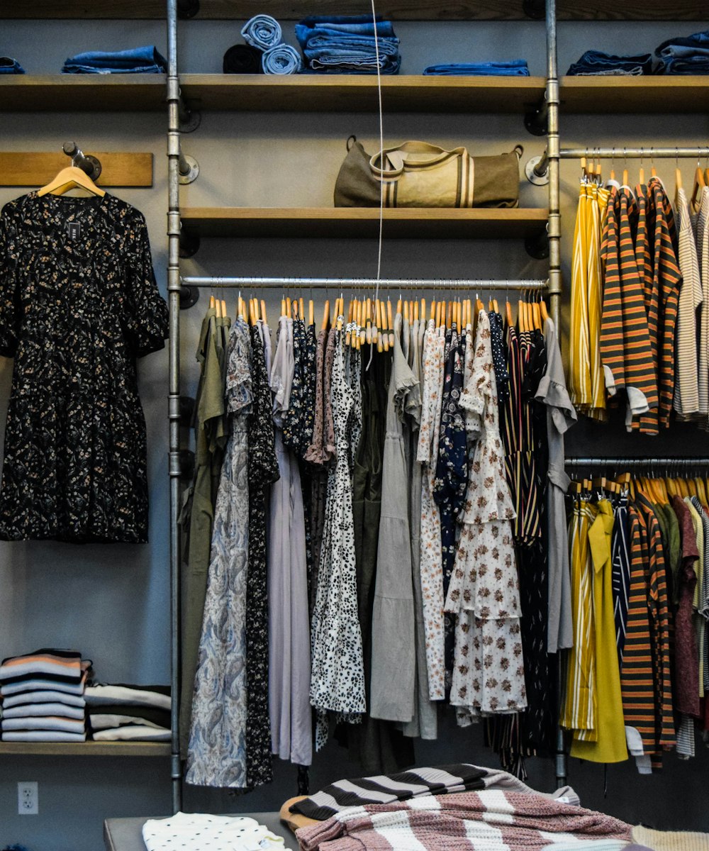 A styled rail of thrifted denim, dresses and striped tops