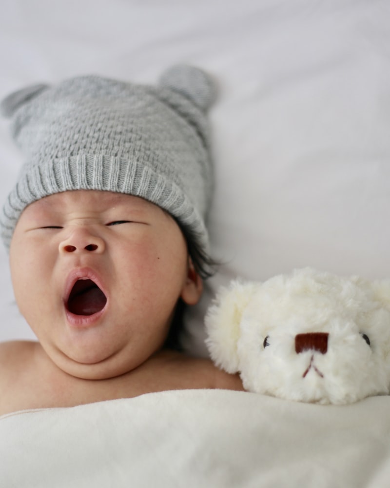 Sleeping newborn in a soft knit bear hat