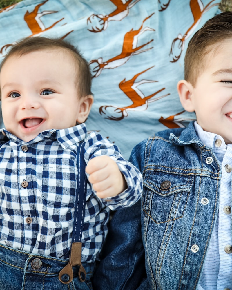 Two smiling babies in gingham and denim