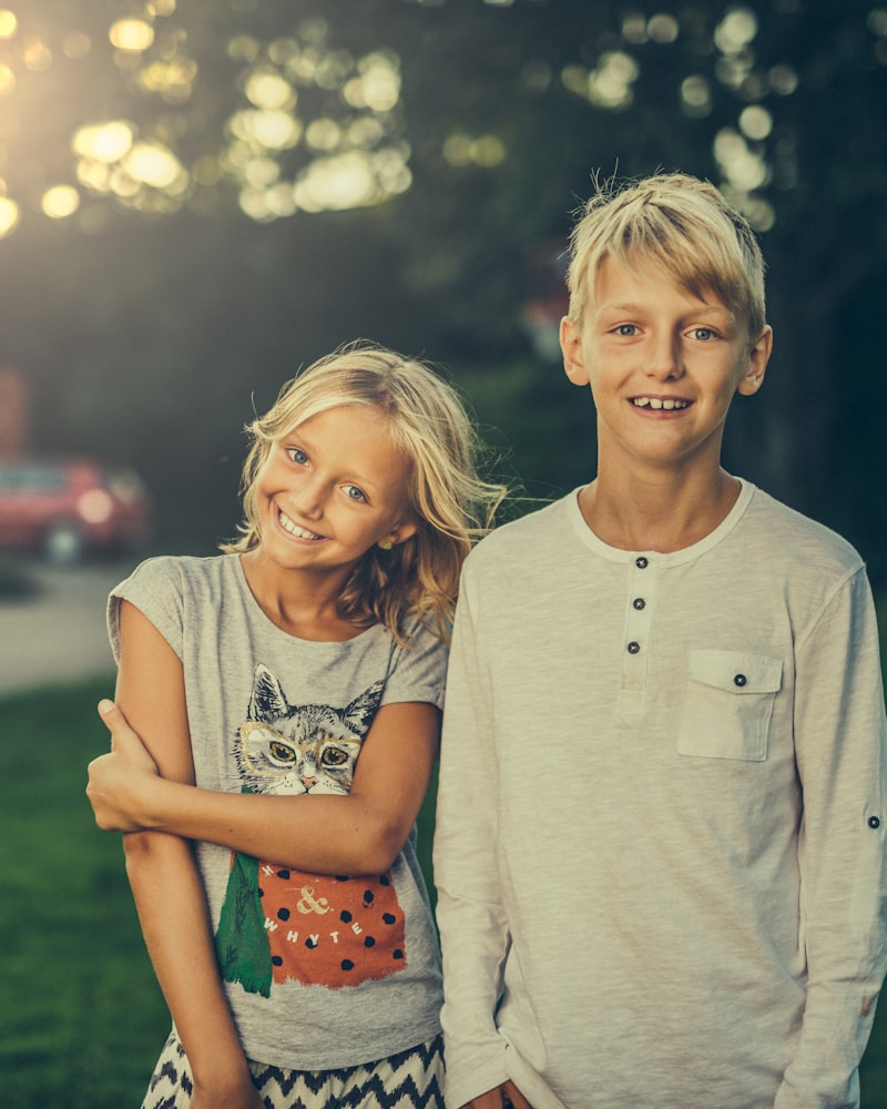 Two older children smiling in the evening sun