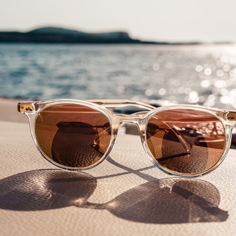 Translucent amber round sunglasses on warm sand