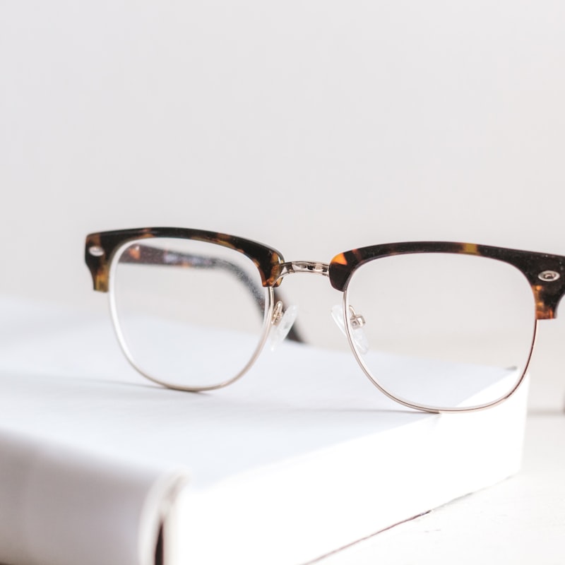 A honey tortoise browline frame on a white book