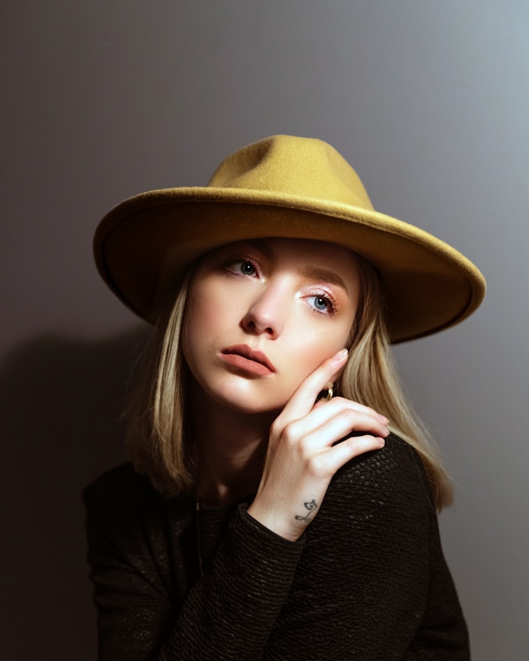 A person wearing a mustard felted-wool wide-brim hat