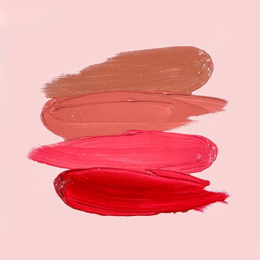Four creamy lip swatches painted in nude, coral, pink and red on a pink background