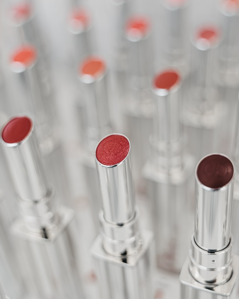 A row of vivid red and coral lipstick bullets