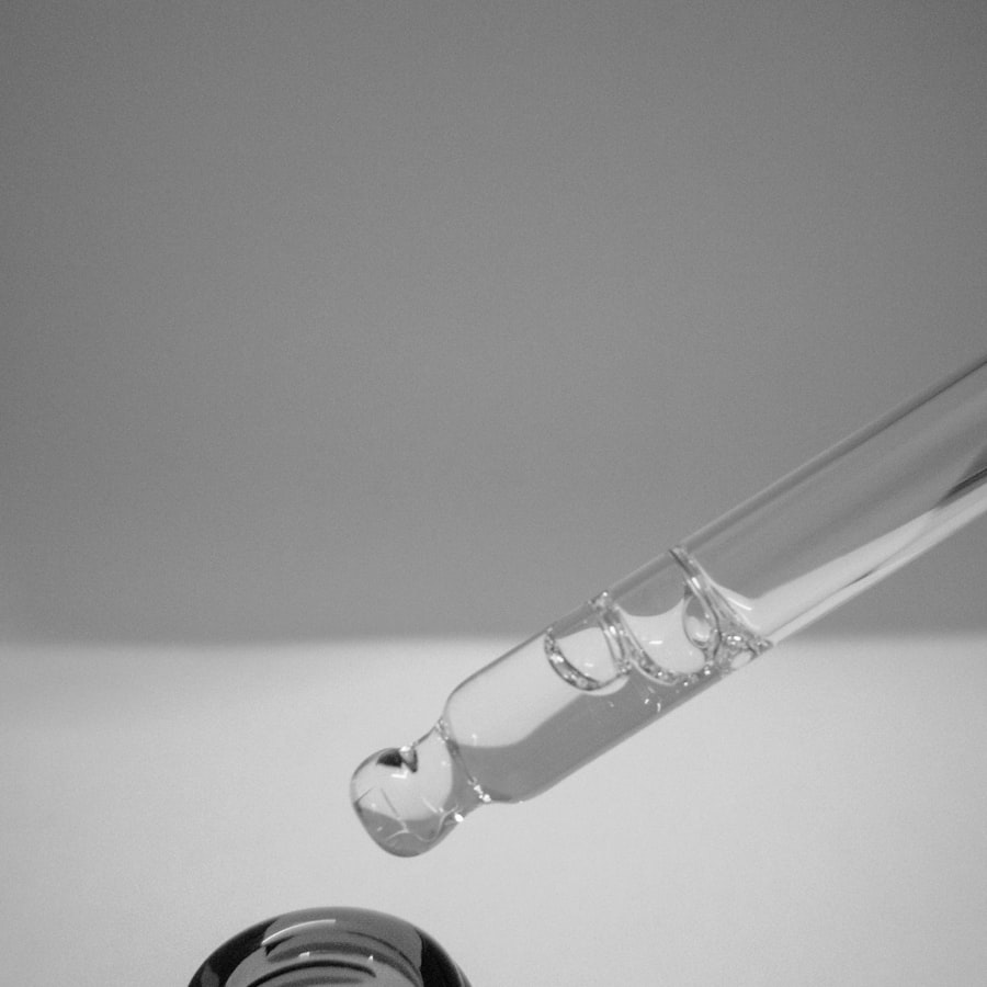 A glass pipette releasing a single drop of facial oil