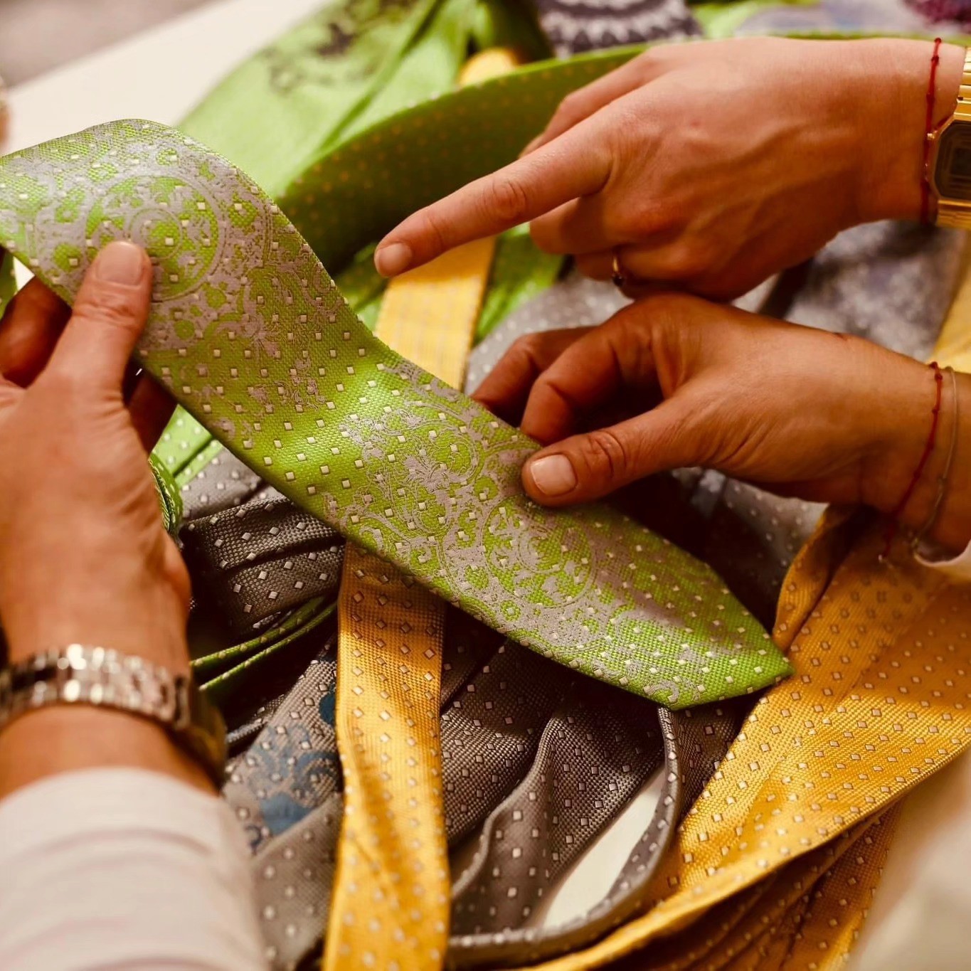 Hands finishing a piece with patterned silk trims