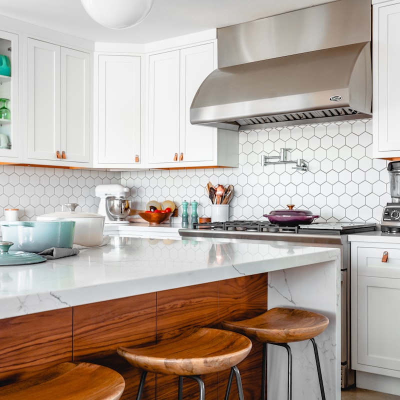 Chef's kitchen with a honed marble island, integrated appliances, and walnut cabinetry.