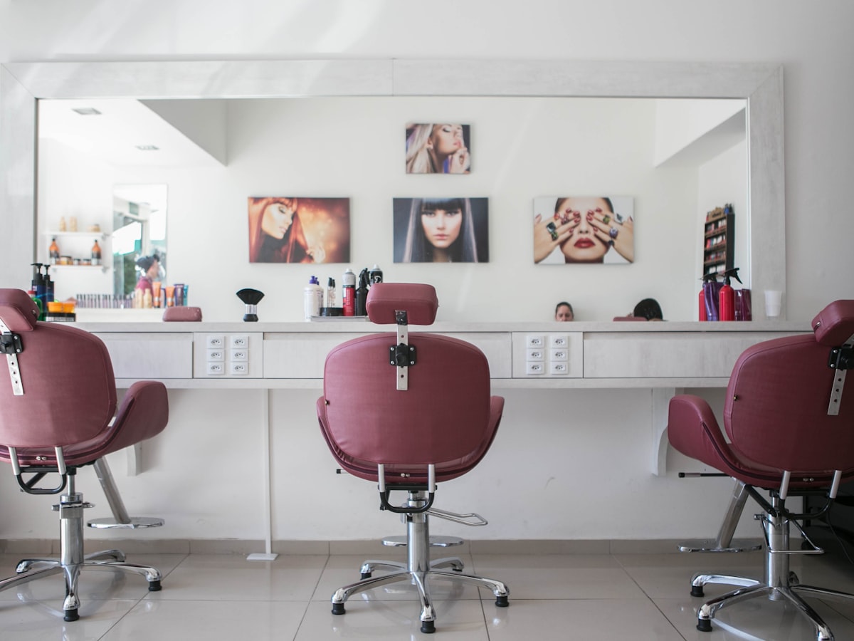The light-filled interior of Lumière Hair Studio with mauve styling stations and large mirrors