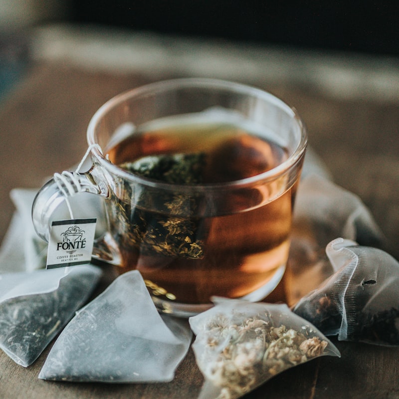 Herbal tea service on a wooden tray beside a candle