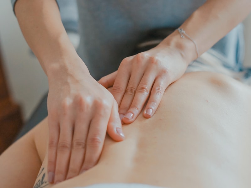 Therapist performing a warm aromatherapy oil massage on a guest's shoulders