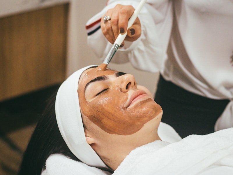 Calm facial treatment with green botanical mask applied in a softly lit spa room