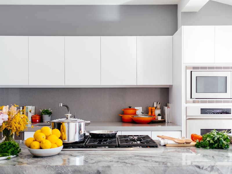 Sparkling white kitchen with marble counters and a bowl of fresh lemons