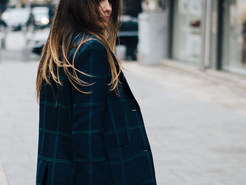Editorial street-style frame of a woman in a tailored check coat