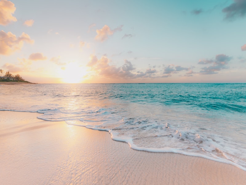 Calm beach shoreline under a pastel sunset sky