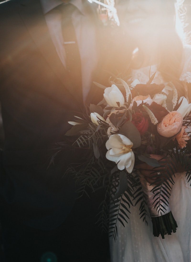 Wedding bouquet held by a groom with warm backlight