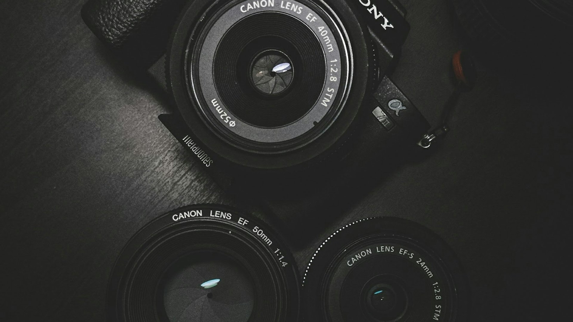 Camera body and a set of prime lenses arranged on a dark surface