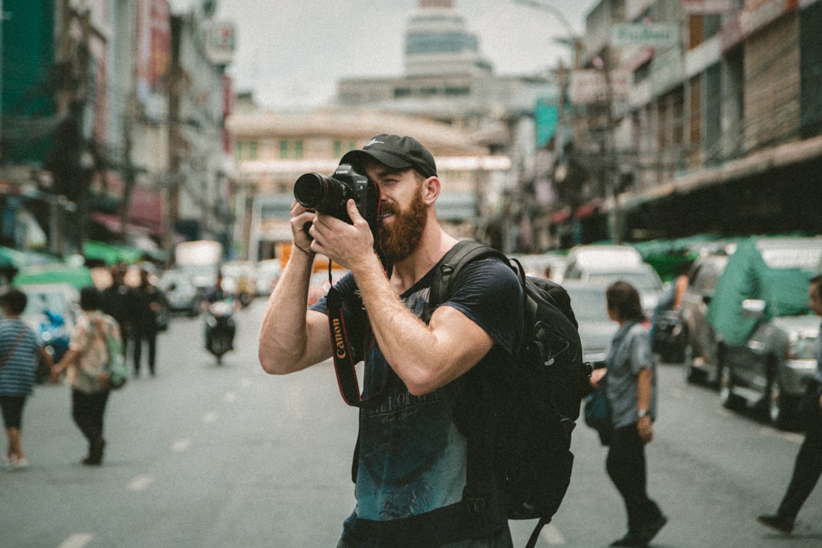 Photographer shooting on location with a handheld camera on a busy street