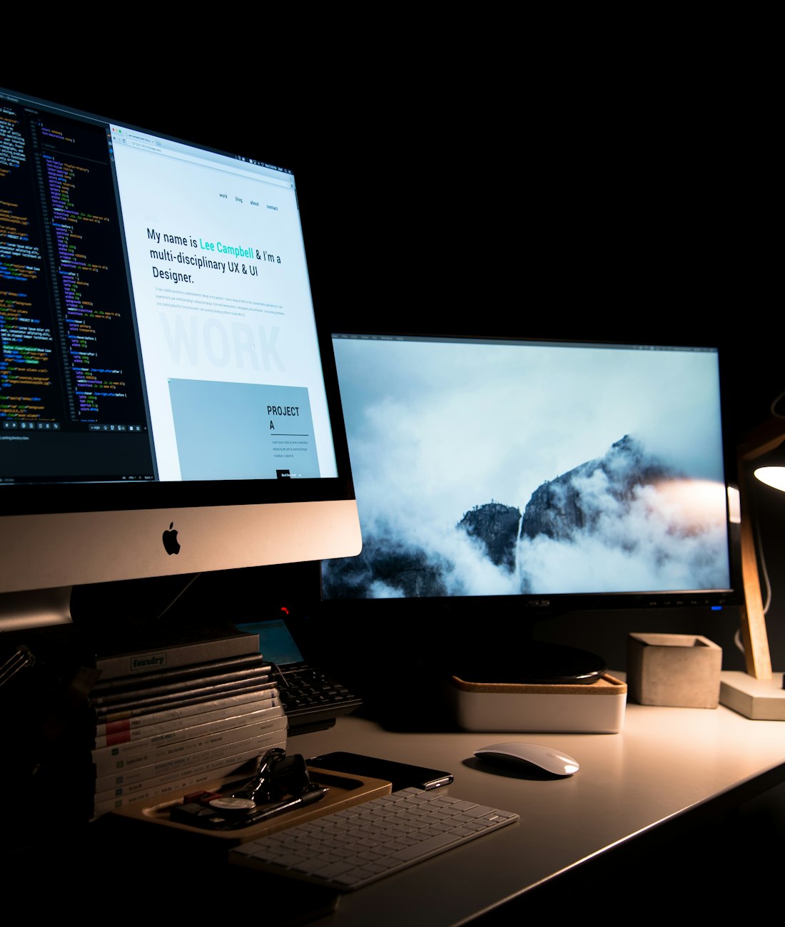 Dim home studio at night: a code editor and a portfolio site open across two screens