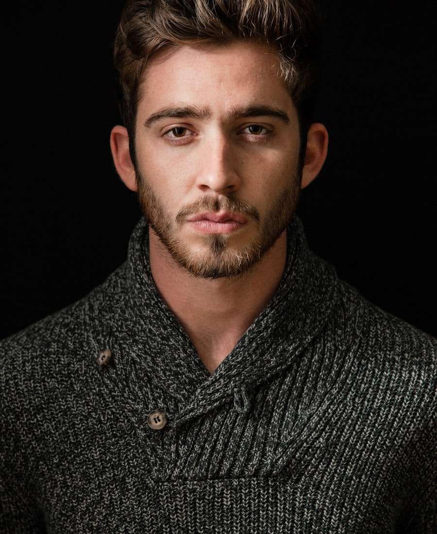Portrait of Jordan Avery, a designer with a beard and textured knit sweater, against a dark backdrop