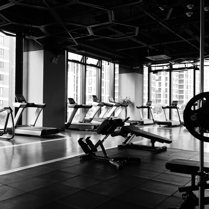 Black-and-white view of the main training floor with treadmills and benches