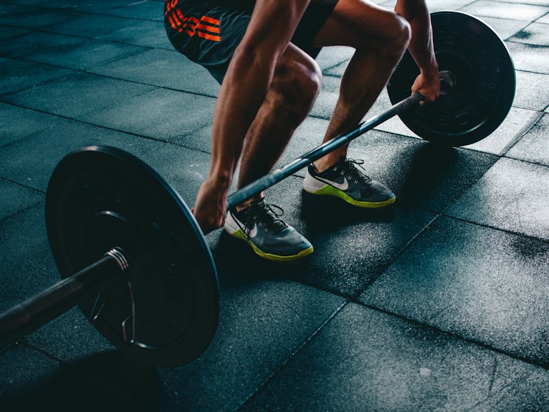 Member gripping a loaded barbell ready to deadlift
