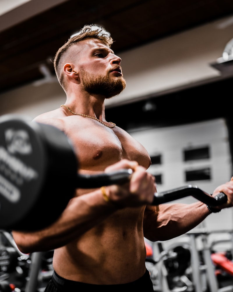Muscular member lifting an EZ curl bar on the gym floor