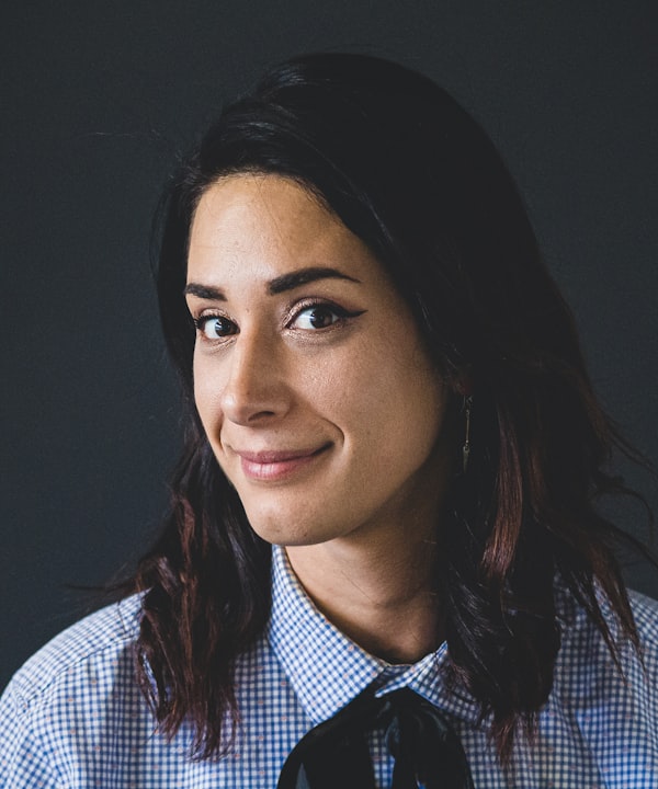 Portrait of Lena Faye, smiling, in a checked shirt