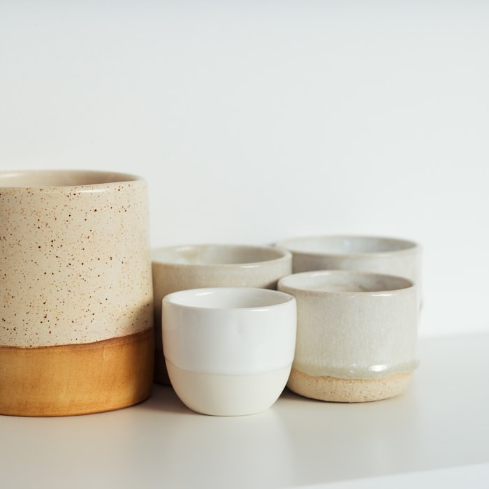 A grouping of cream and stoneware ceramic cups in soft, earthy tones