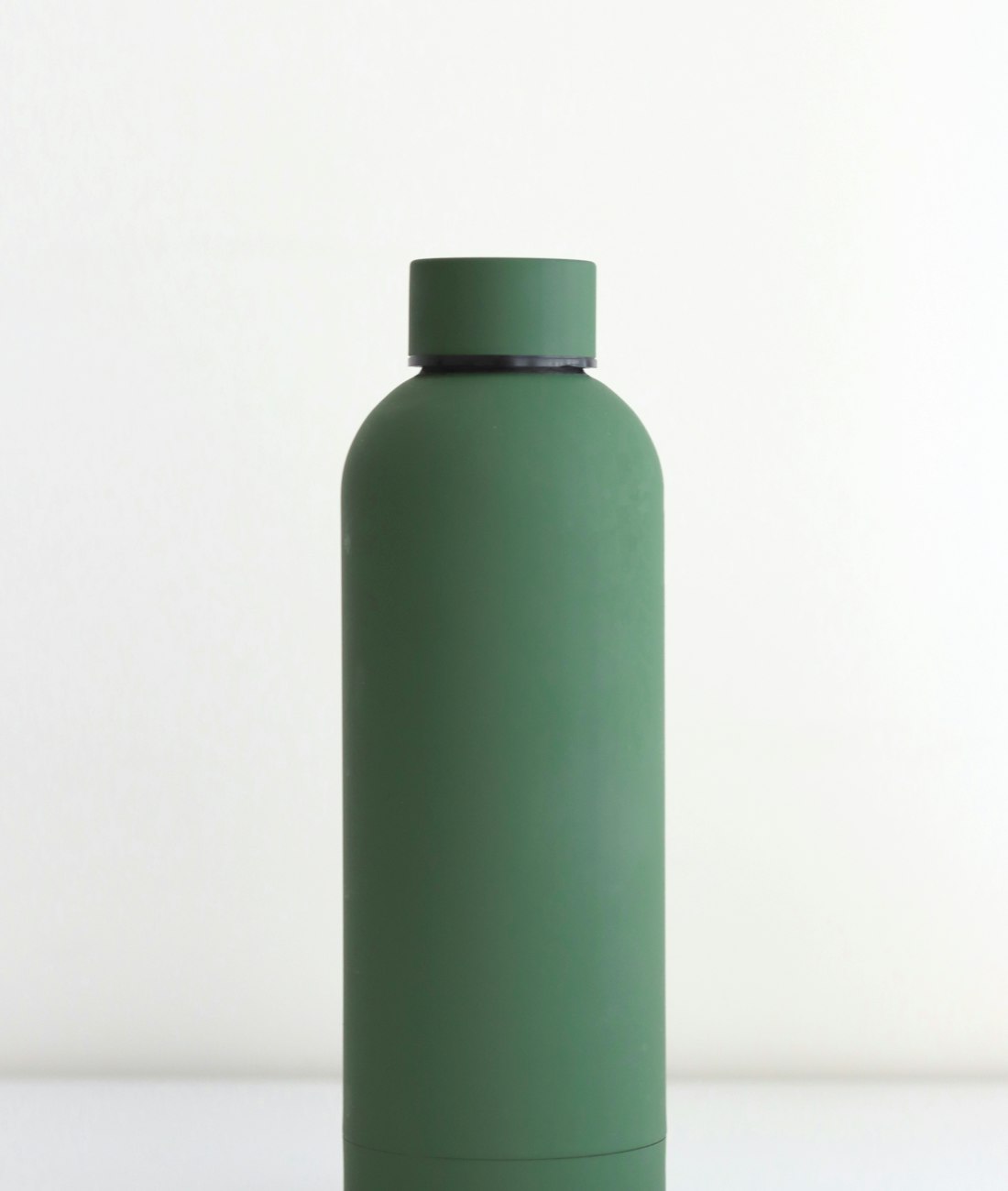 Hale insulated water bottle in forest green standing on a pale studio backdrop