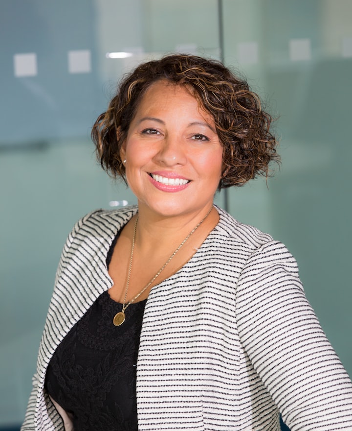 Portrait of Renata Cole, host, smiling with short curly hair