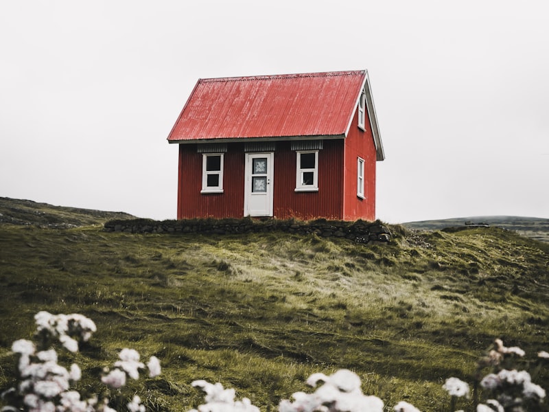 A small warm home on a green hillside representing safe housing