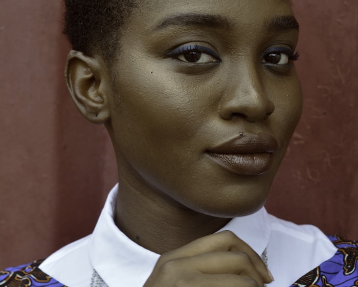 Amara, a young woman with a calm confident expression, in a crisp white collar