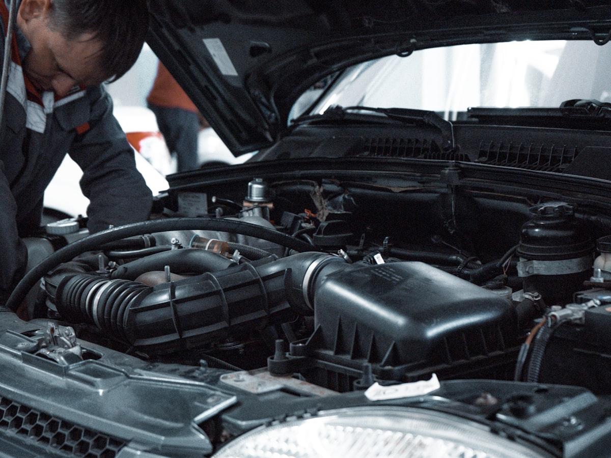 ASE-certified technician inspecting an engine bay in the Apex Auto Works service shop