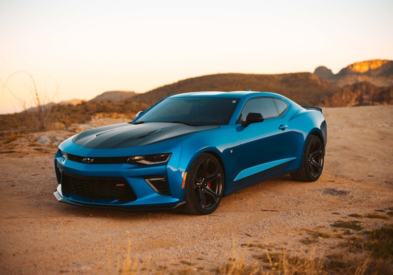 Electric-blue 2022 Chevrolet Camaro SS coupe parked against a desert backdrop at golden hour