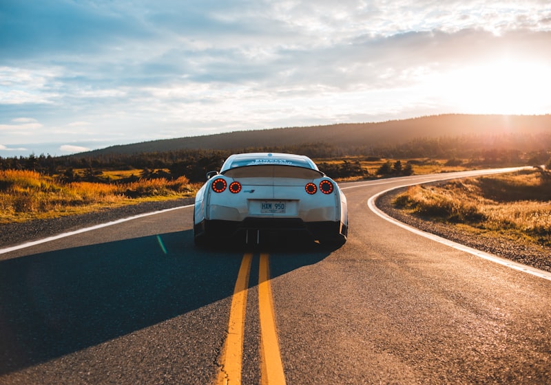 White 2019 Nissan GT-R coupe on a sunlit open road