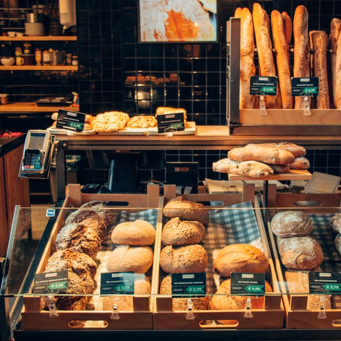 Bakery display counter stacked with rustic loaves and baguettes