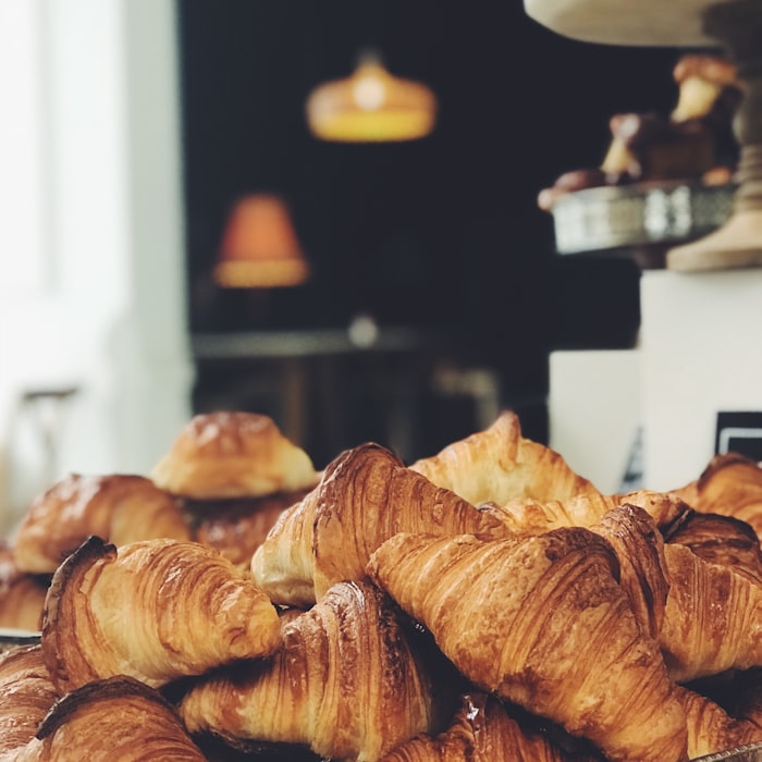 A heaping pile of golden croissants in a cozy bakery
