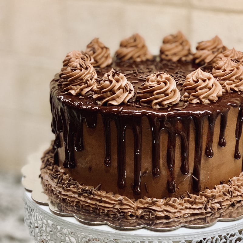 Chocolate layer cake with chocolate drip and piped buttercream rosettes