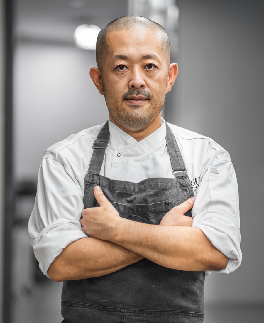 Executive chef Marco Devlin in chef whites and apron, arms crossed, in the kitchen.