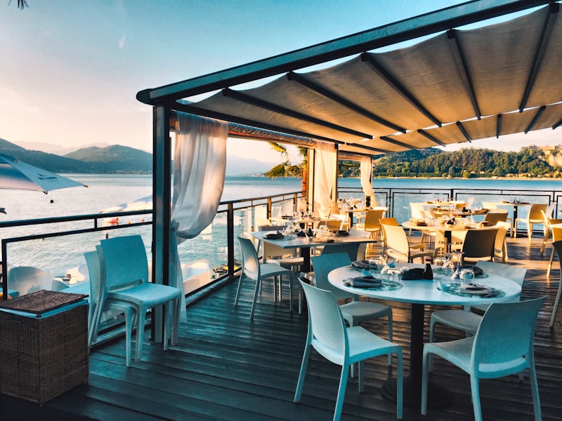 An intimate waterside dining terrace set for a private dinner at golden hour.