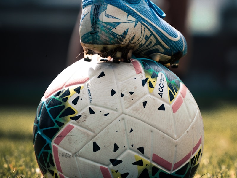 Close-up of a player's boot resting on the matchball before kickoff